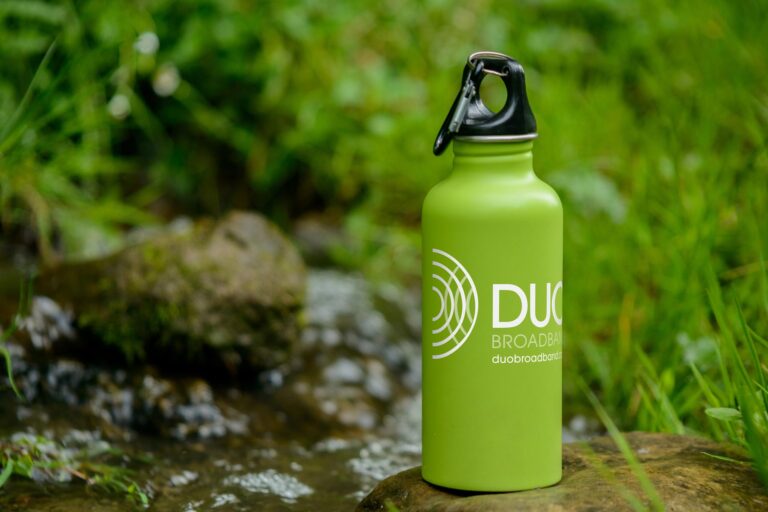 Water bottle on rock outdoors with DUO Broadband logo