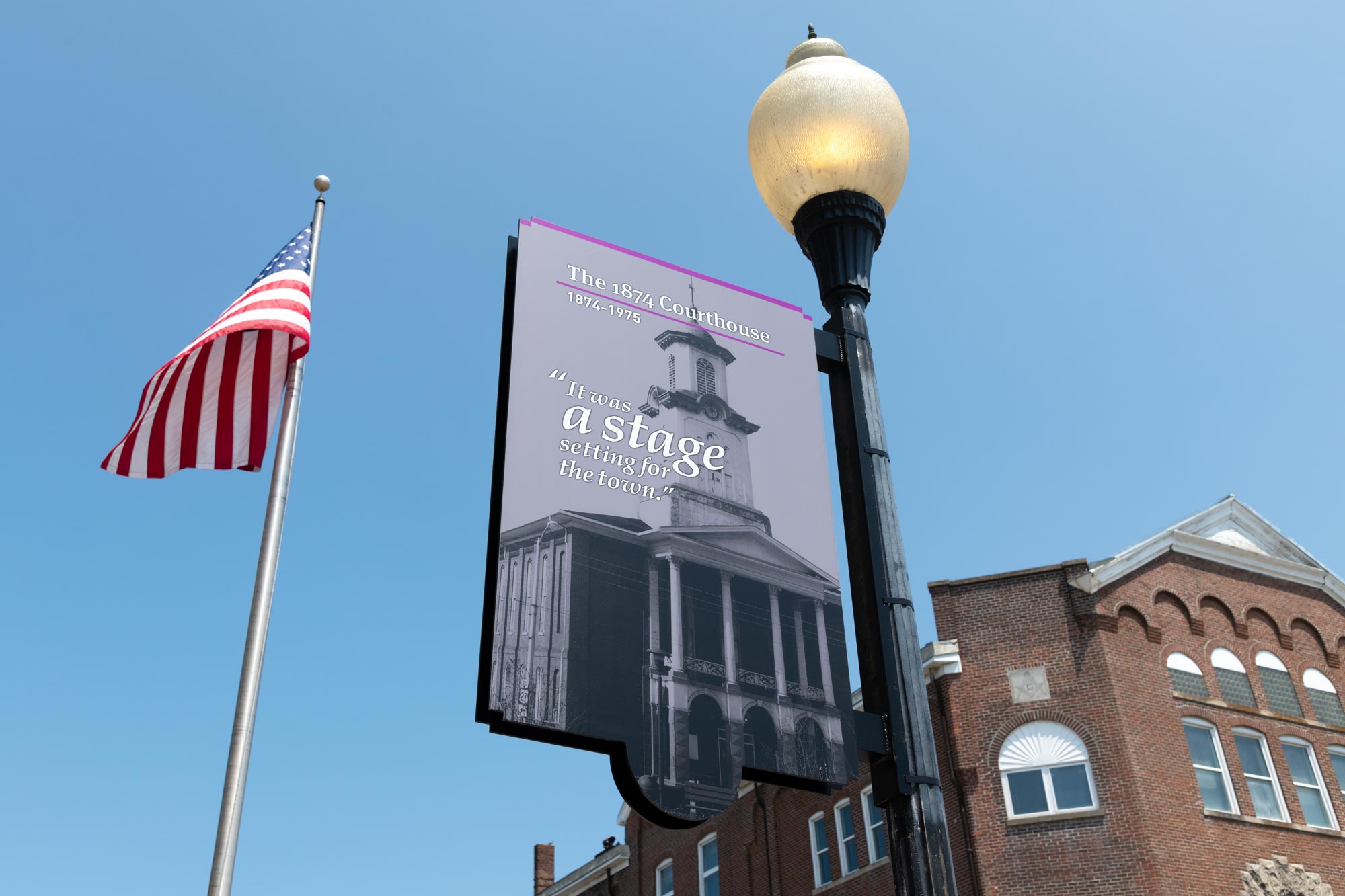 Lamp post mounted sign with image of old courthouse.