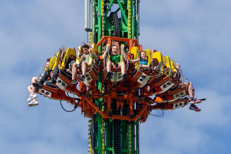 Kids on a carnival ride with excited expressions.