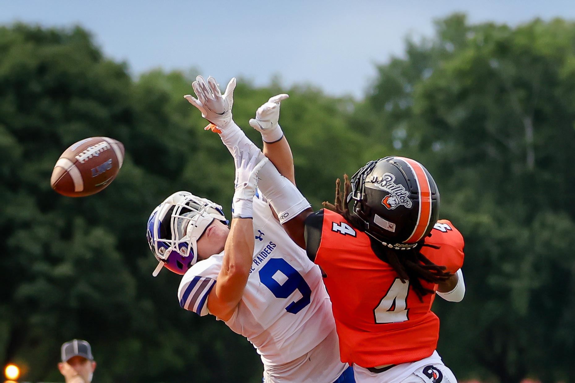 Football players in action with Bulldogs logo on one helmet