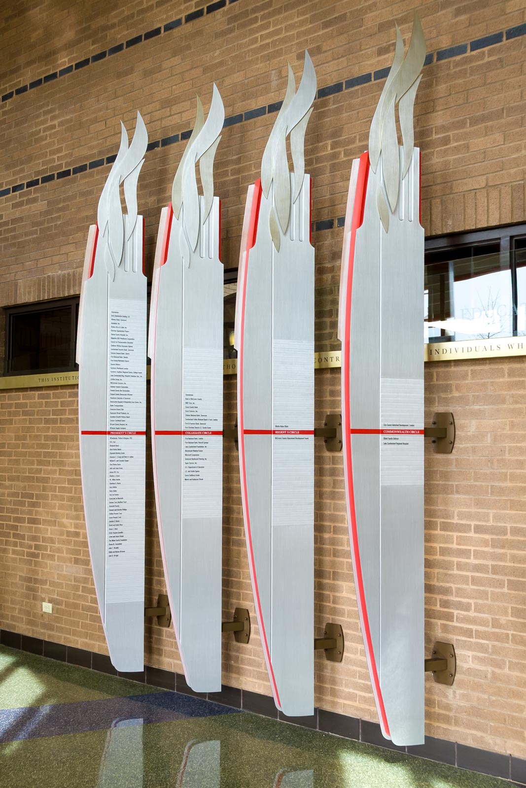 Tall metal sign panels in the shape of stylized flames with donor names