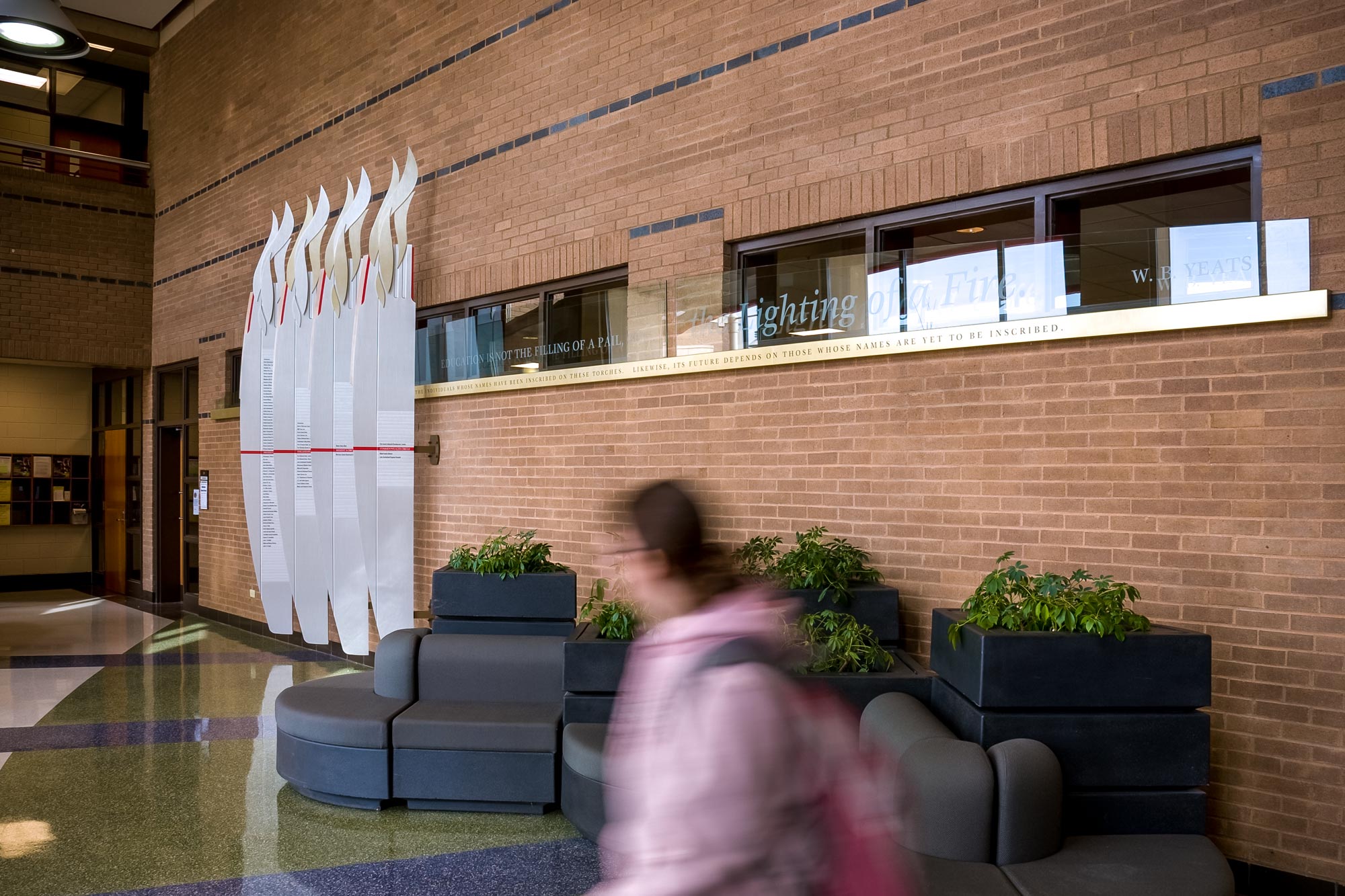 wide view of lobby and student walking by the donor wall