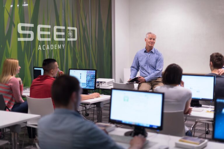 Classroom with students and SEED ACADEMY logo on a wall