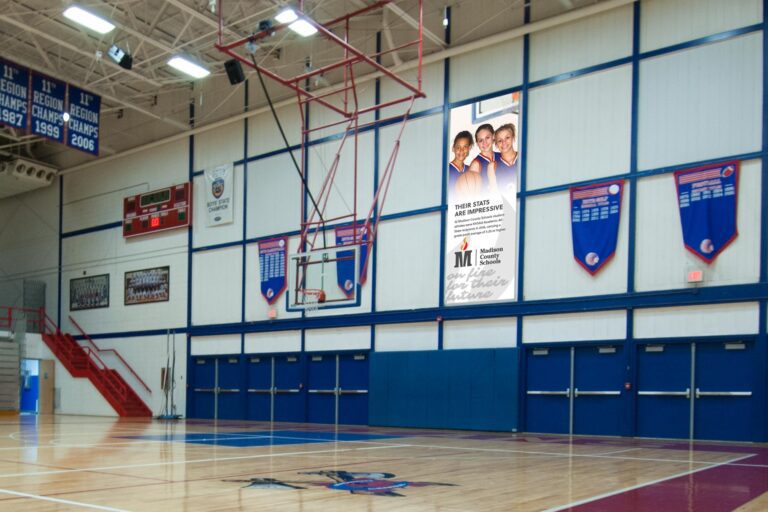 Large Madison County Schools banner in basketball gymnasium.