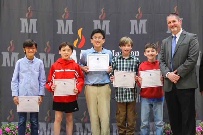 Students holding certificates in front of a Madison Schools logo backdrop