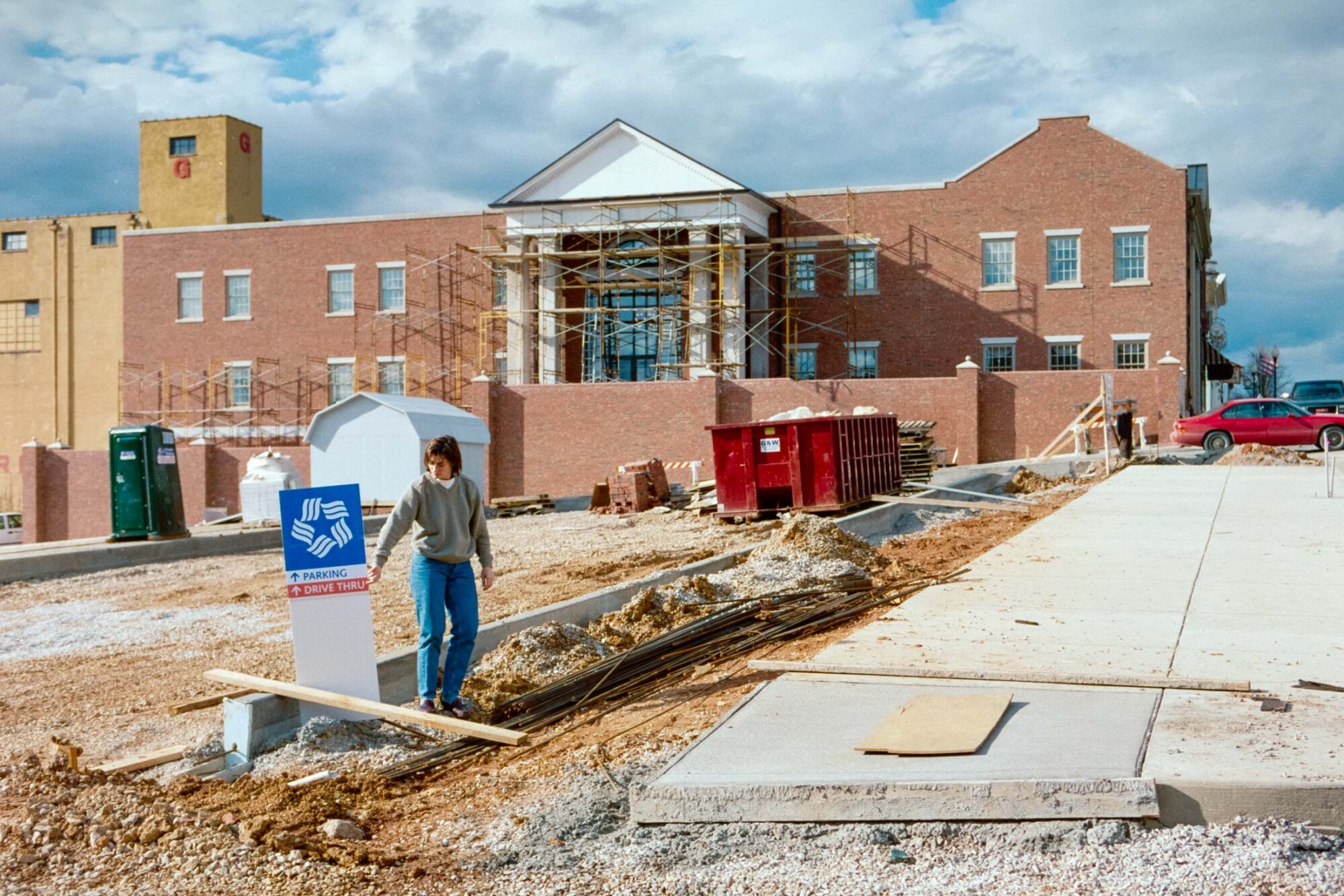Cumberland Security Bank early sign prototype testing during construction. Woman next to temporary sign at construction site.