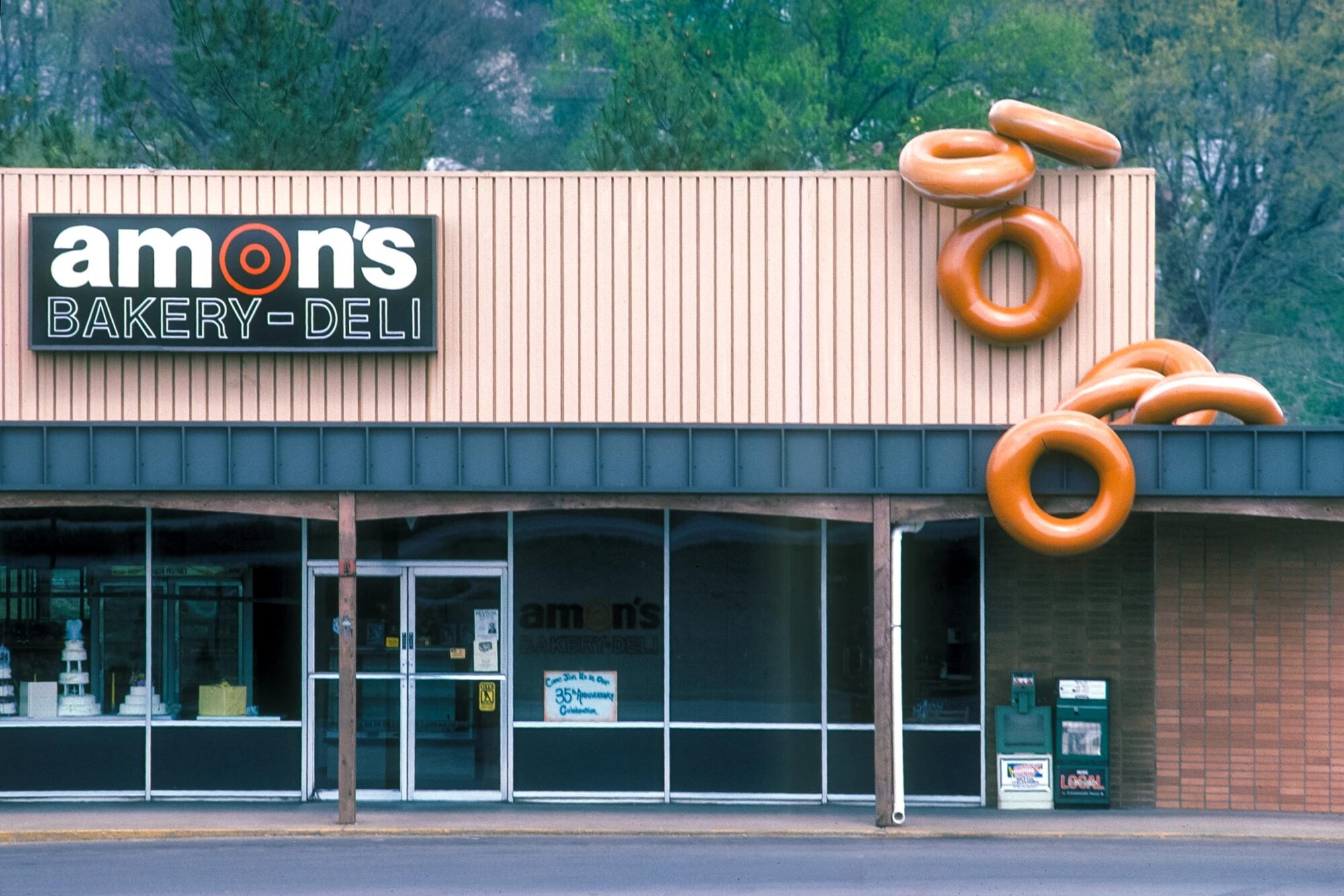 Amon's Bakery with Large donuts spliing from the roof. Inter tubes pained to look like glazed donuts.