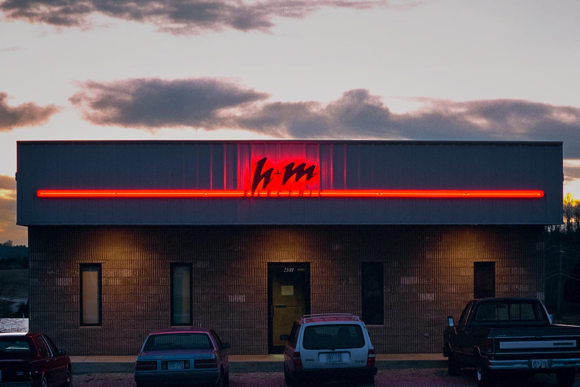 H+M building with neon electric sign silhouetting the company logo