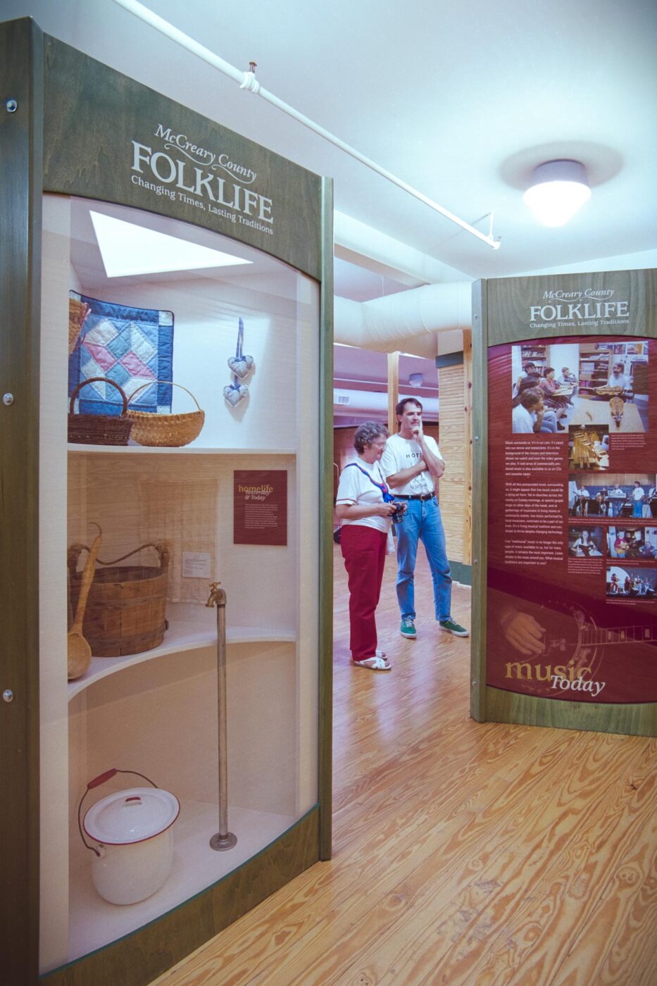 people looking at the McCreary County Folklife exhibit kiosks