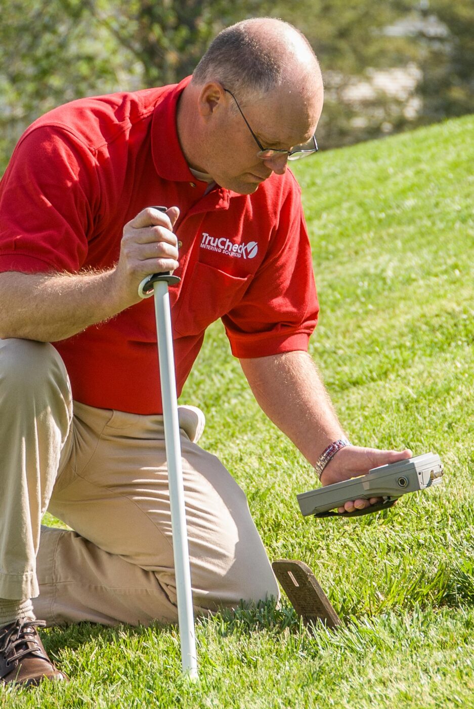 Man in TruCheck uniform reading a water meter