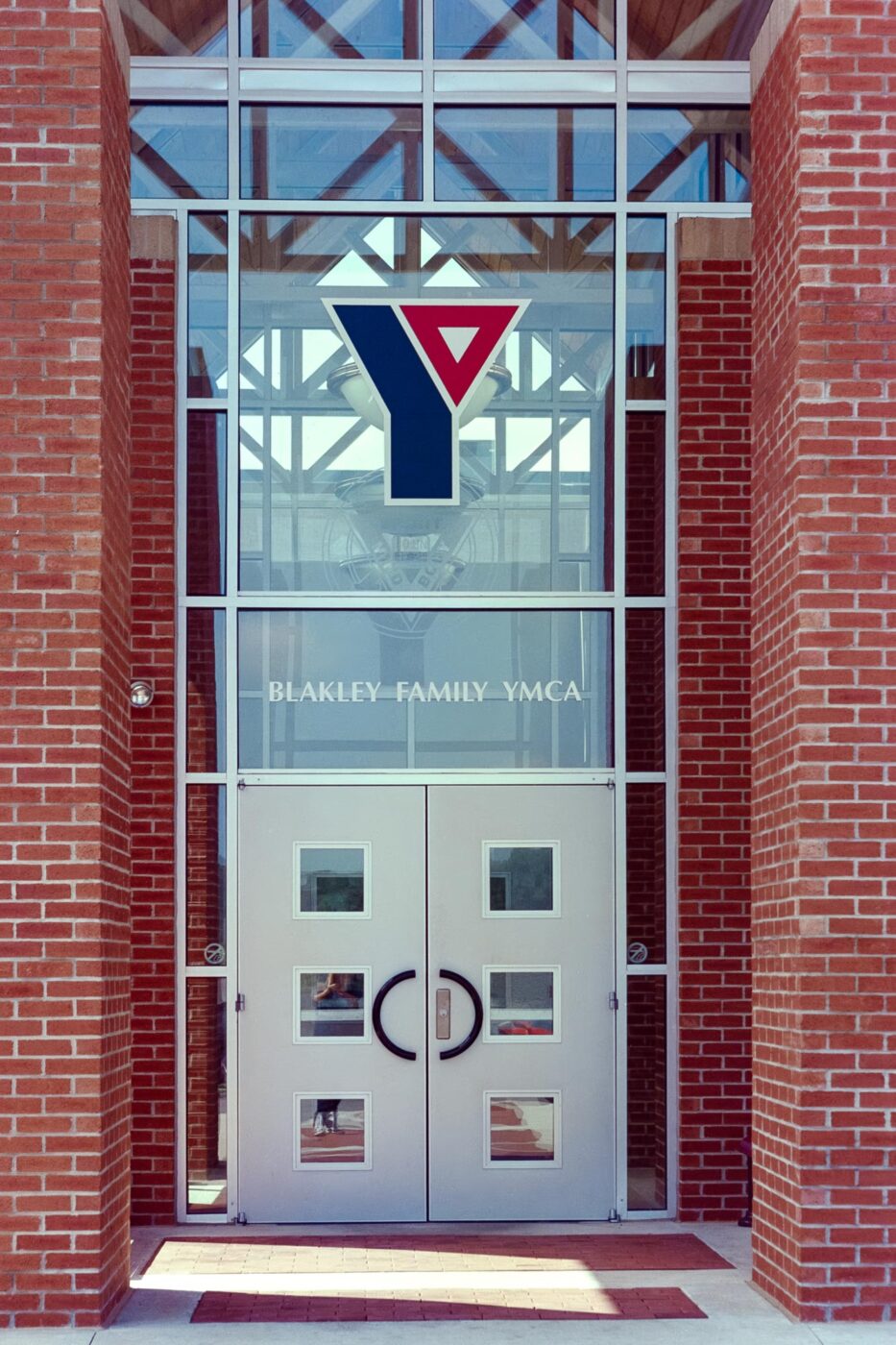 Blakley Family YMCA front doors with glass applied signage graphics.